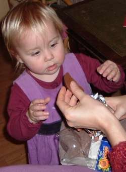 Anna gives Lily a slice of chocolate orange