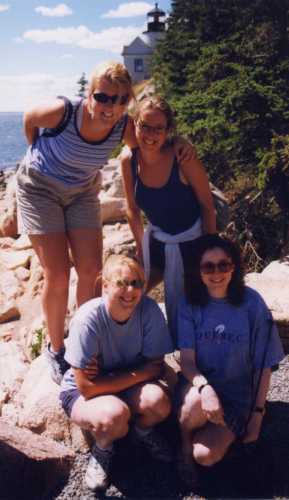 the girls pose by the lighthouse